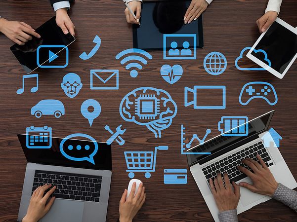 Personen arbeiten an Laptops, umgeben von digitalen Cloud- und IT-Symbolen.