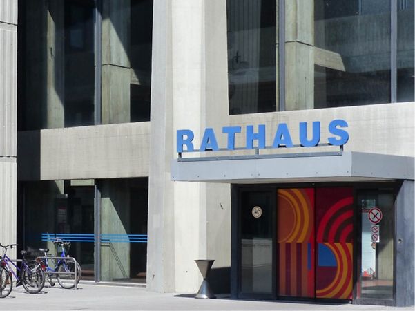 Eingangsbereich des Rathauses Offenbach mit Schriftzug und abgestellten Fahrrädern.