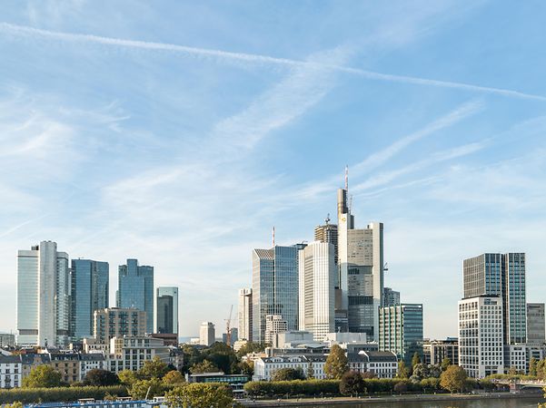 Stadtansicht von Frankfurt mit moderner Skyline und Hochhäusern bei klarem Himmel.