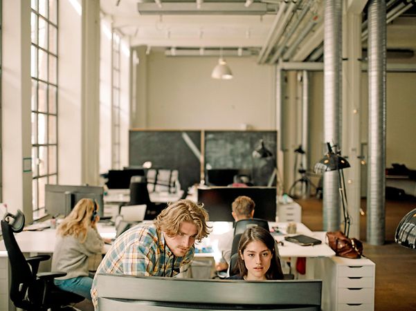 Mehrere Personen arbeiten gemeinsam im Büro verbunden durch Standortvernetzung