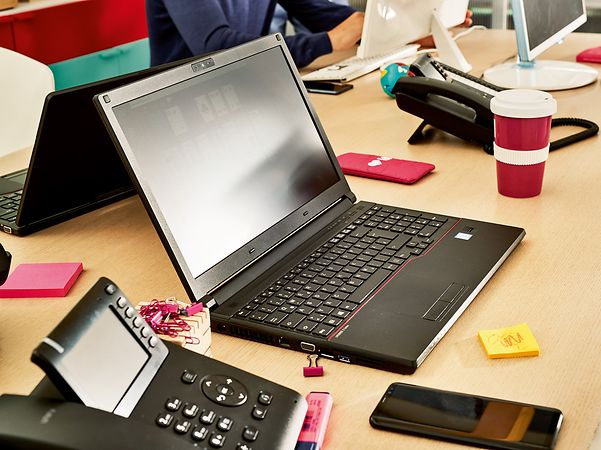Schwarzer Laptop, der mit CompanyFlex verbunden ist, steht auf Schreibtisch.