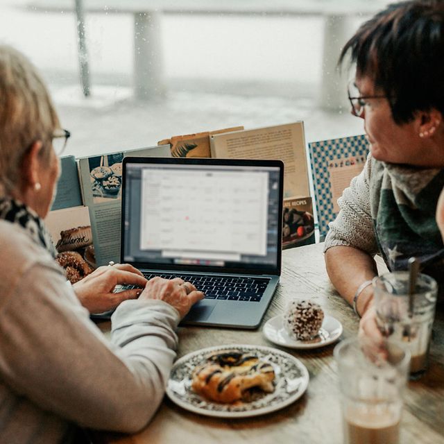 Zwei Personen arbeiten gemeinsam am Laptop am Tisch