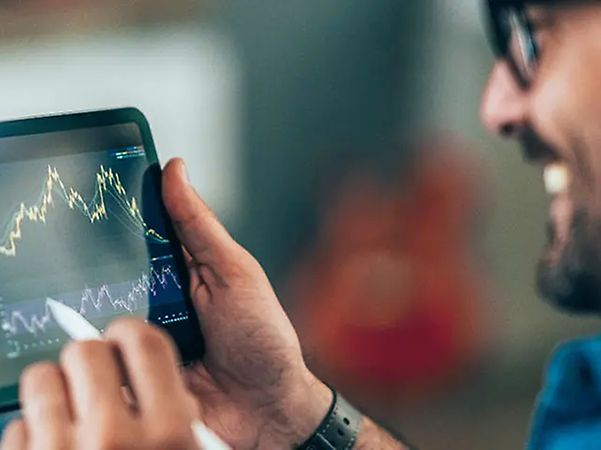 Person zeigt Finanzkennzahlen auf Tablet