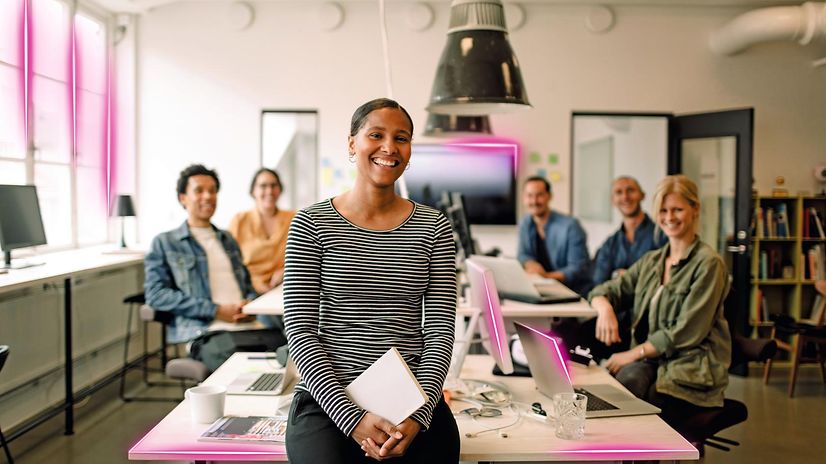 Vier Personen arbeiten in einem Büro an Laptops.