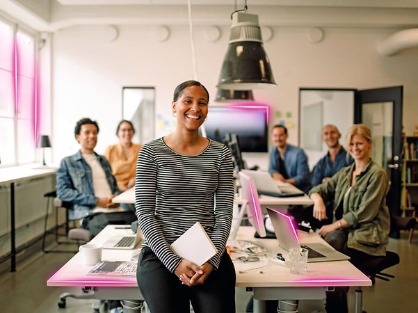 Vier Personen arbeiten in einem Büro an Laptops.