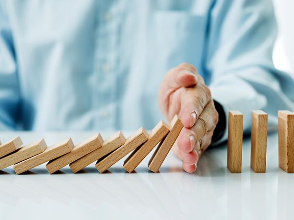 Hand stoppt fallende Holzsteine für Incident Response Services.