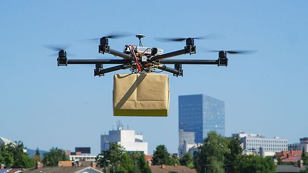 Drohne transportiert ein Paket über einer Stadtlandschaft