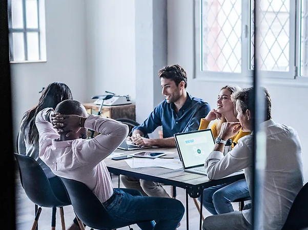 Personen sitzen um einen Tisch und arbeiten gemeinsam an einem Meeting