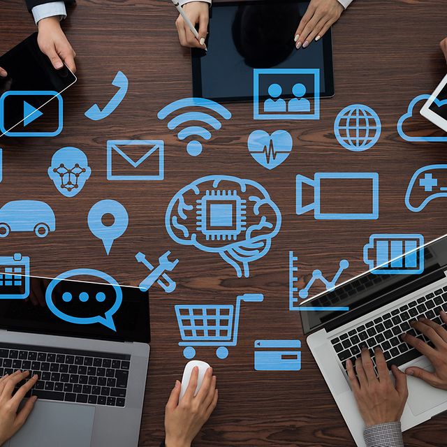 Personen arbeiten an Laptops, darüber Symbole für digitale Vernetzung
