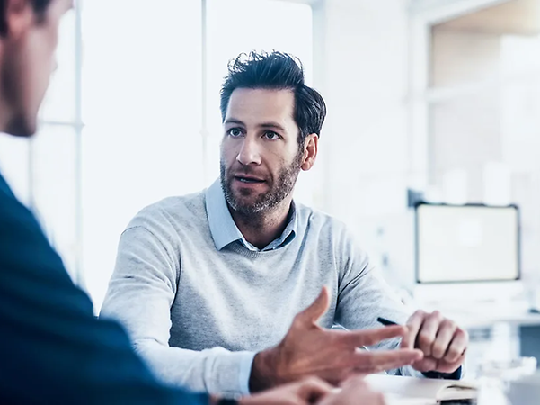 Zwei Personen im Gespräch an einem Tisch im Büro