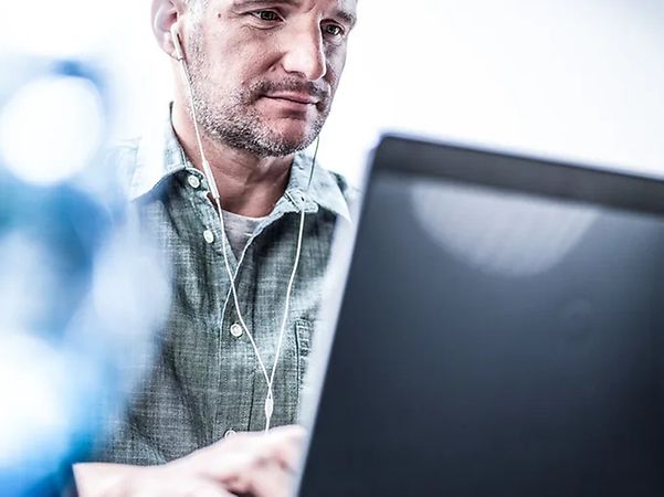 Person arbeitet an einem Desktop-PC im Büro.