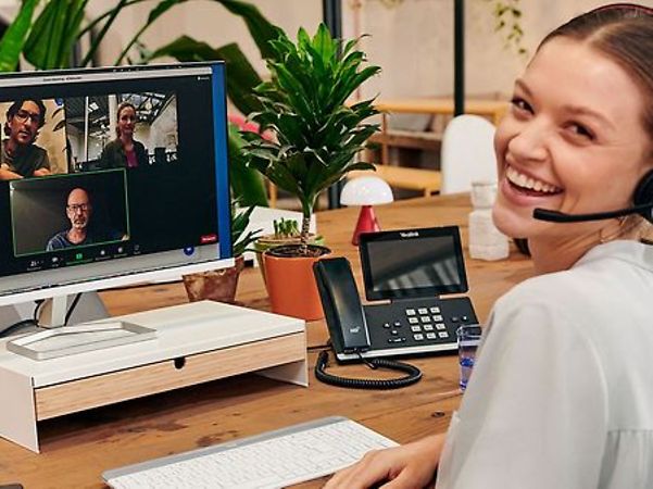 Frau lacht während einer Videokonferenz in die Kamera. 