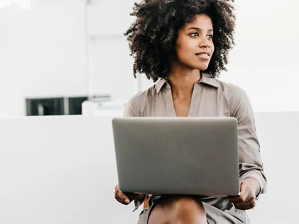 Frau arbeitet am Laptop und nutzt Industrial AI Cloud der Telekom